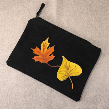 Ein Stück Pappel Blatt und ein Stück Ahornblatt Aufnäher zum aufbügeln auf einem schwarzen Etui als Beispiel auf einem neutralen Hintergrund