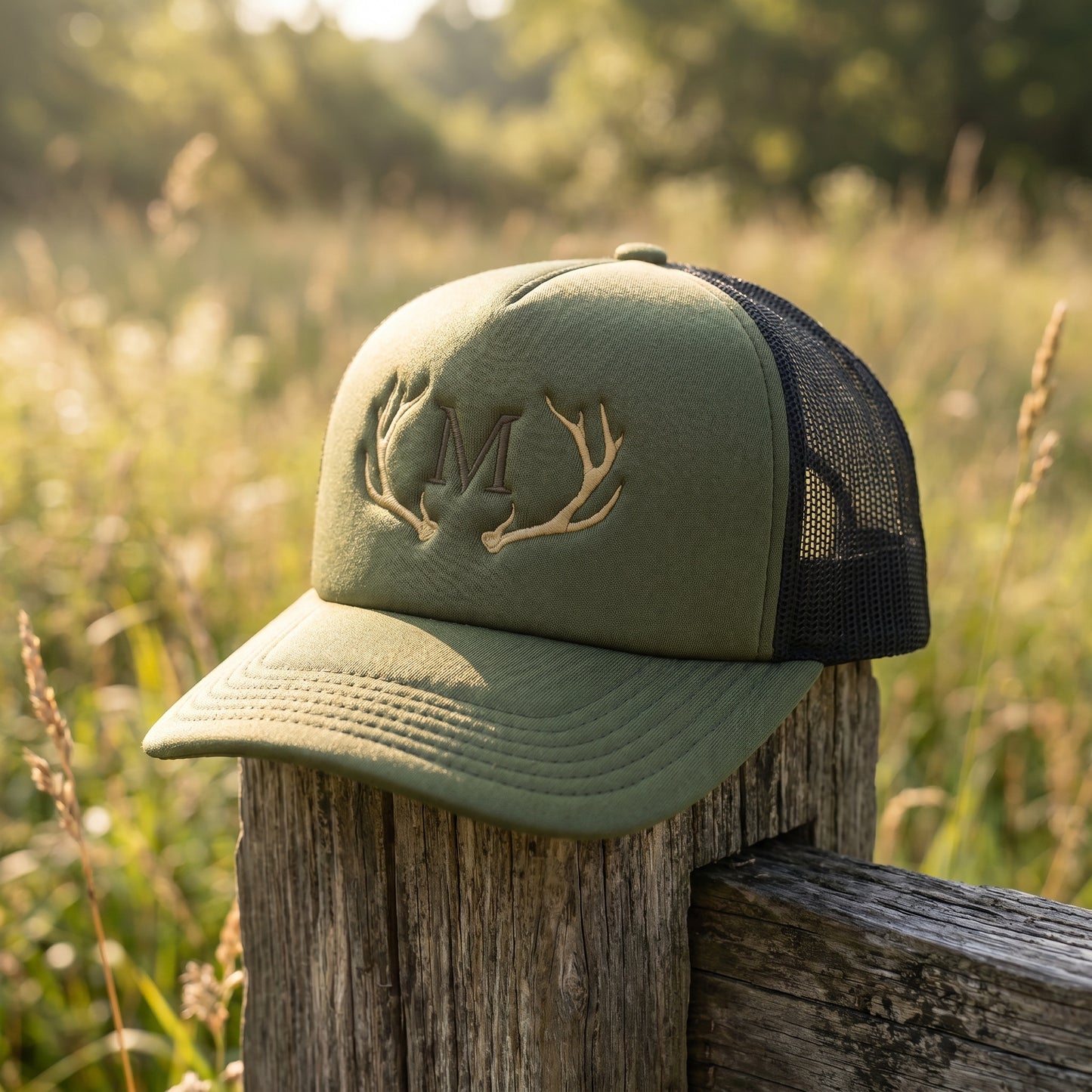 Olivgrünes Trucker Cap auf einem Stück Holz in der Natur.