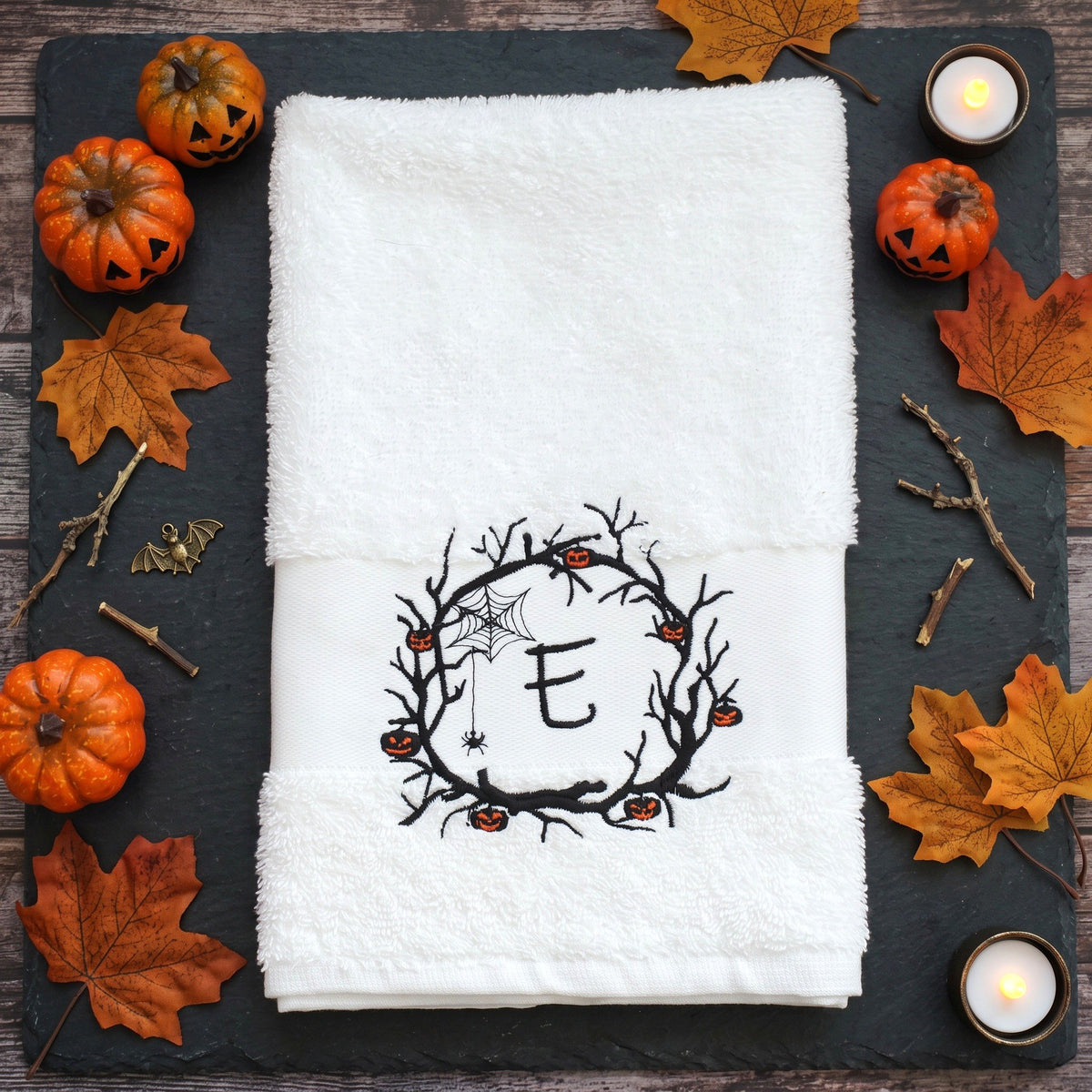 Personalisiertes weißes Handtuch mit bestickter Initiale E im Halloween Spuk-Kranz und brennender Kerze