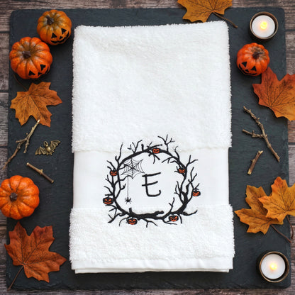 Personalisiertes weißes Handtuch mit bestickter Initiale E im Halloween Spuk-Kranz und brennender Kerze