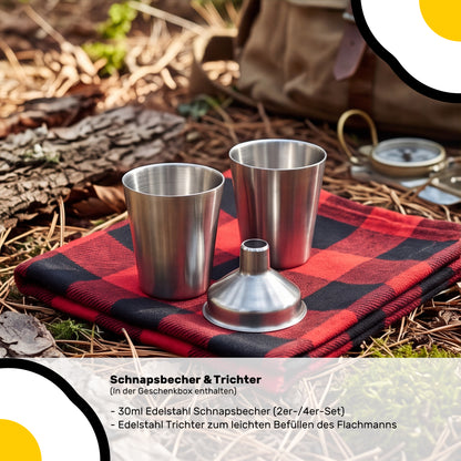 Zwei Edelstahl 30 ml Schnapsbecher und ein Trichter auf einem roten Tuch und Naturboden.