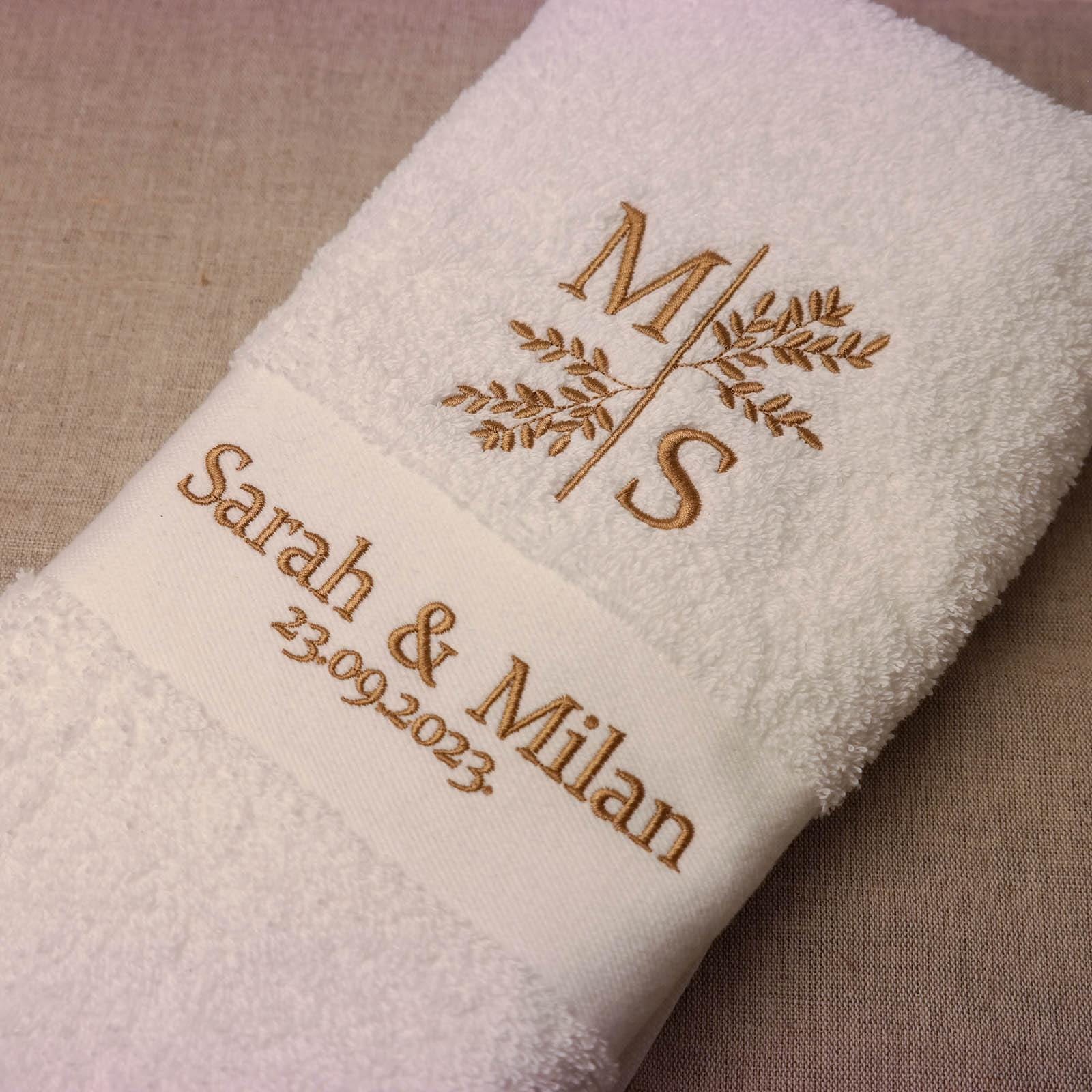 Detail Stickerei Initialen mit Blumenmotiv, Datum und Namen auf personalisiertem weißem Handtuch