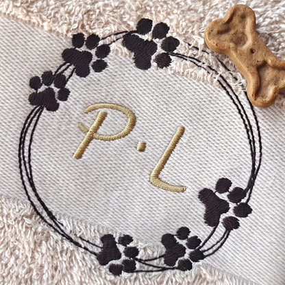 Sandfarbiges besticktes Handtuch mit einer Pfotenkranz und Initialen Stickerei in Dunkelbraun und Gold. Nahaufnahme